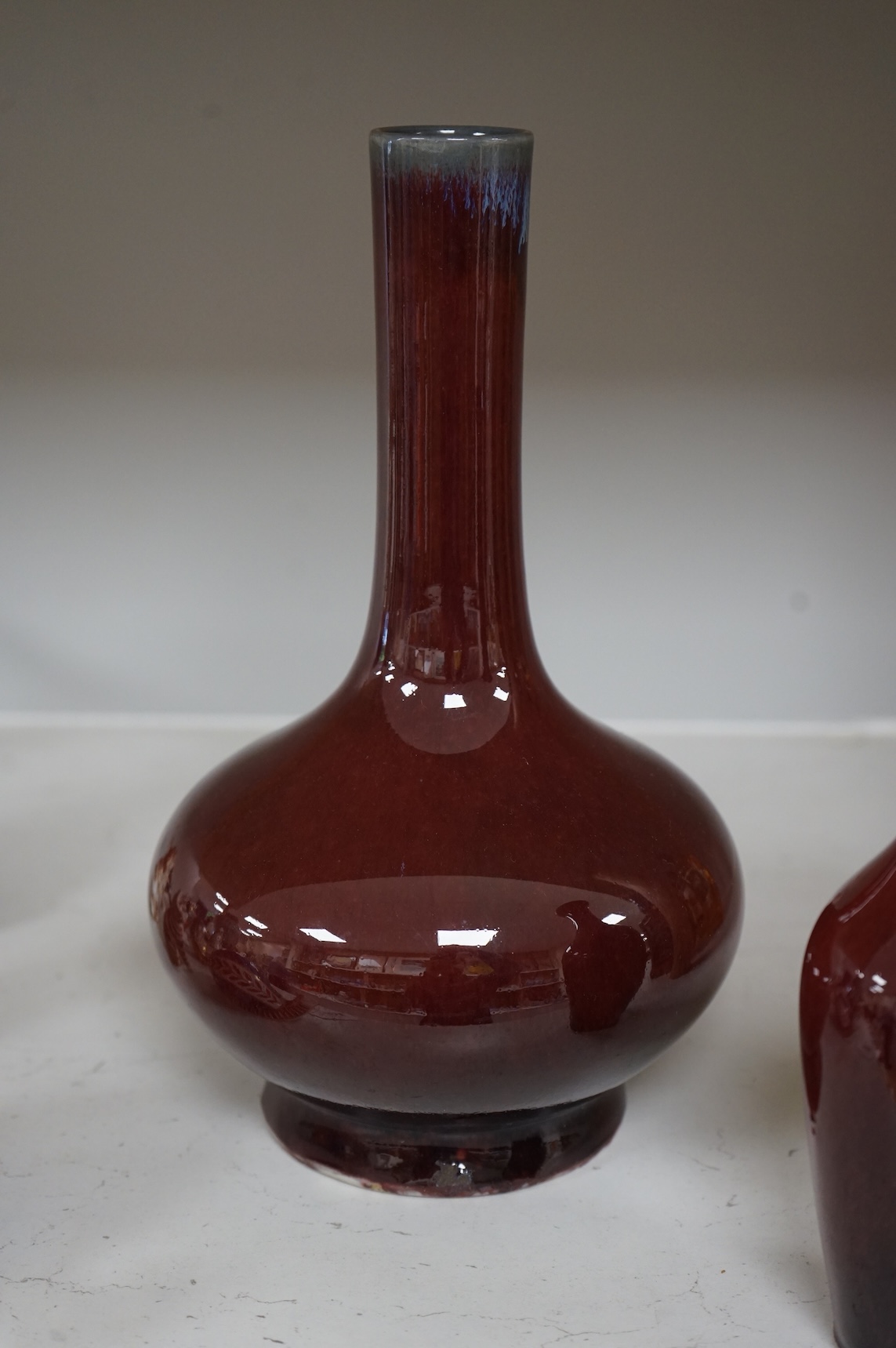 Two Chinese Sang de Boeuf glazed vases to include a bottle neck example, largest 27cm high